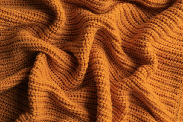 istock Beautiful orange knitted fabric as background, top view 1423573672
