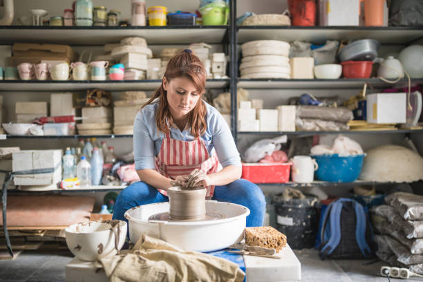 istock Young women, making pottery on a pottery wheel in the art studio. 1423573839
