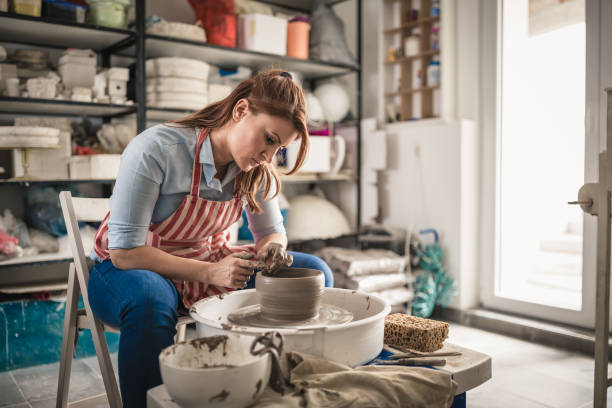 istock Young women, making pottery on a pottery wheel in the art studio. 1423573867