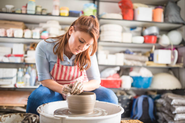 istock Young women, making pottery on a pottery wheel in the art studio. 1423573874