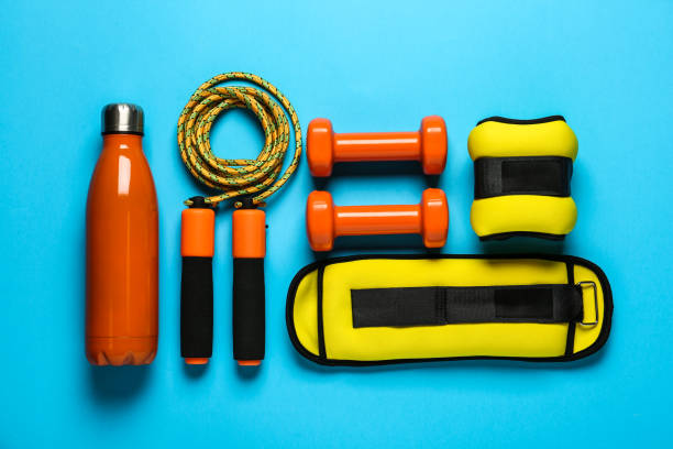 istock Yellow ankle weights and sport equipment on light blue background, flat lay 1423574758