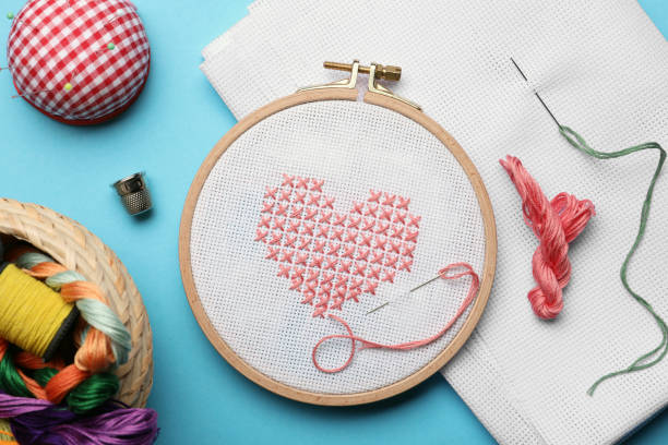 istock Flat lay composition with embroidery and different sewing accessories on light blue background 1423575309