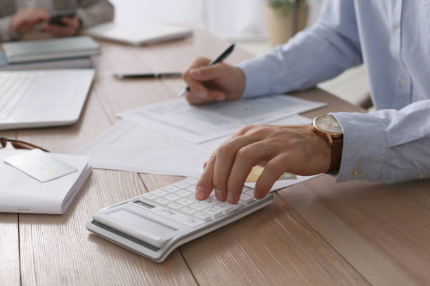 istock Tax accountant with calculator working at table in office, closeup 1423575598