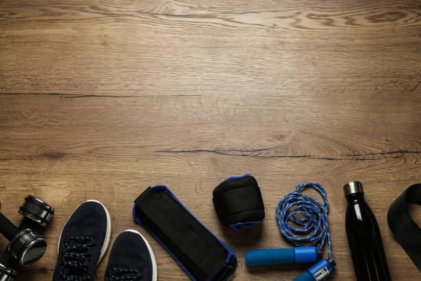 istock Blue ankle weights and sport equipment on wooden table, flat lay. Space for text 1423575599