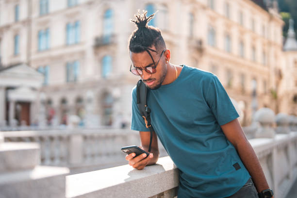 istock Cool Young African American Male Using A Smart Phone While Commuting In The City 1423576028