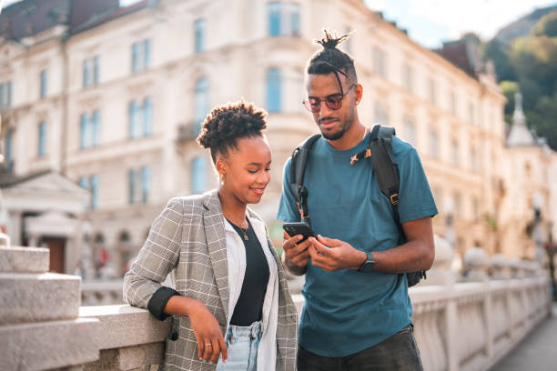 istock Handsome Young Black Couple Using Smart Phones While Hanging Out In The City 1423576032