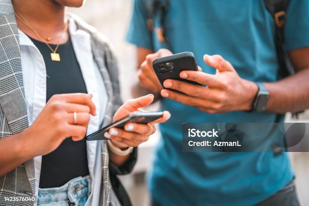 Handsome Young Black Couple Using Smart Phones While Hanging Out In The City Stock Photo - Download Image Now