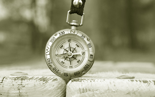 Old classic navigation compass on natural background