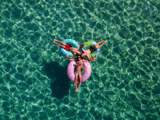 海の膨脹可能なカラフルなリングに浮かぶ人々の無人機での写真 - pleasant bay ストックフォトと画像