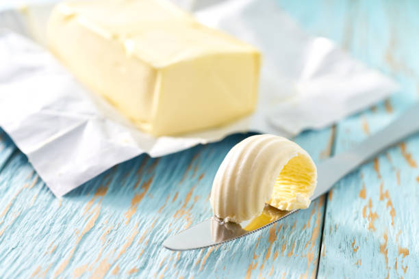 piece of butter on a blue wooden table, selective focus. stock photo