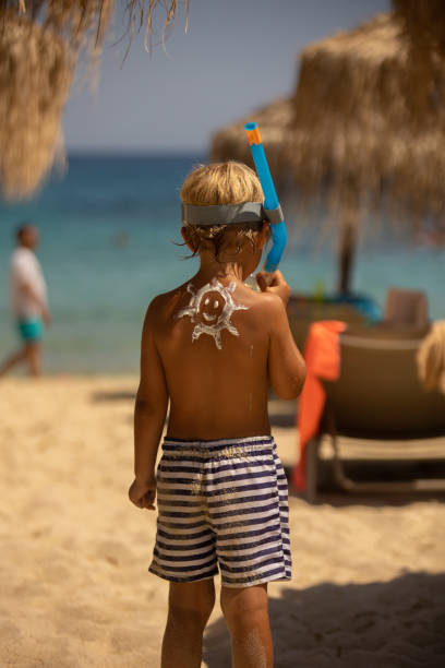 istock Happy child, blond boy on the beach with applied sun screen,  enjoying summer, playing 1423579964