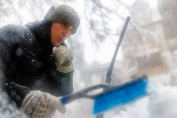 istock A Man is Cleaning a Snow From the Car with Brush. 1423580656
