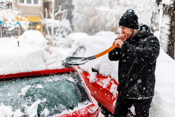 istock A Young Man is Cleaning Snow from a Car with a Shovel. 1423580990