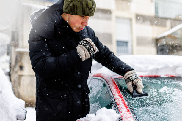 istock A Young Man is Cleaning Ice and Snow from a Car Windshield. 1423582102
