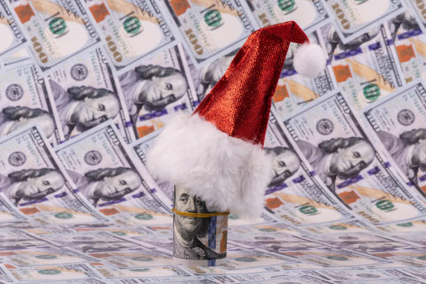 istock 100 american dollar bills and red christmas hat 1423582786