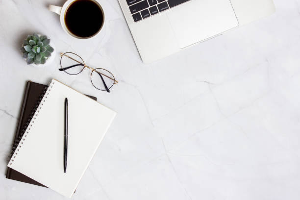 istock Working space with computer, glasses, coffee, notebook and cactus over the marble background. 1423582836