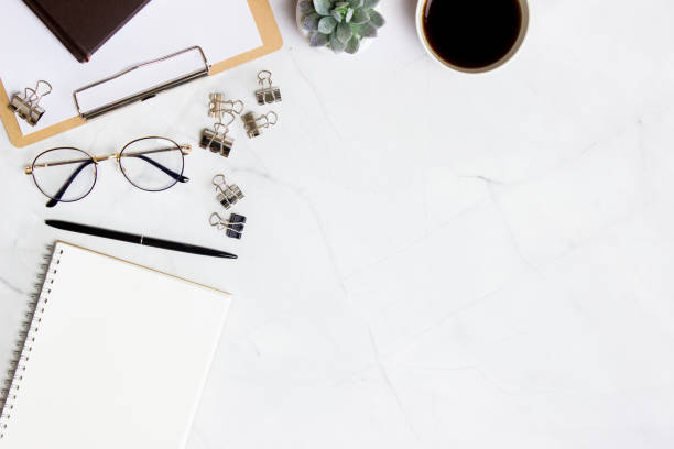 istock Working space with notebook, coffee, glasses, paper over the marble background. 1423582838
