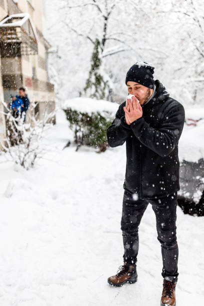 istock Young Man is Blowing a Nose During a Winter Day. 1423582899