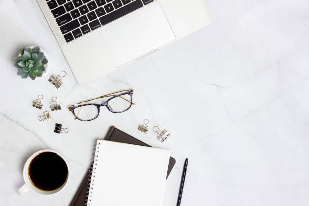 istock Working space with computer, glasses, coffee, notebook and cactus over the marble background. 1423582916