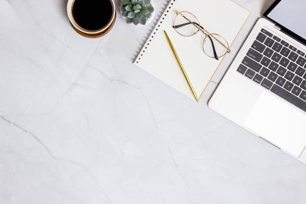 istock Working space with computer, glasses, coffee, notebook and cactus over the marble background. 1423582917
