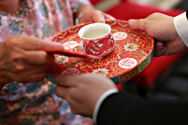 Newlywed serving tea to elder on Chinese traditional tea ceremony stock photo