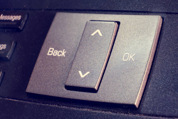 istock Button with the text ok and back on a landline phone in the office, close-up 1423583832