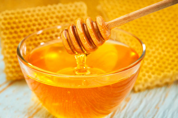 istock bowl sweet honey on blue rustic table, with honeycomb, close-up. 1423583965
