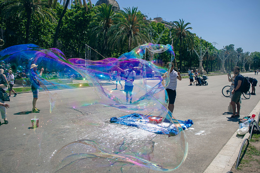 Children's street performer/entertainer blowing huge bubbles for tourists and children in Barcelona, Spain