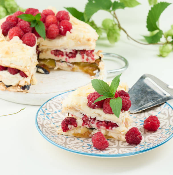 istock Round meringue pie with fresh raspberries on a white background, Pavlova dessert 1423585722