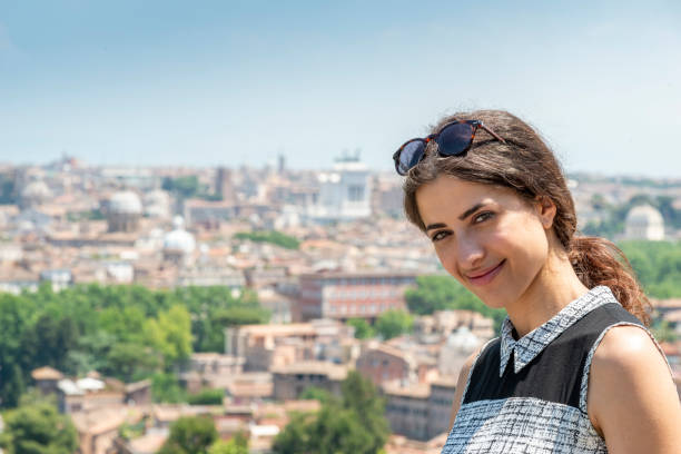 istock Young woman looking at the camera, in back skyline Rome 1423585723
