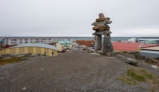 Inukshuk (Inuksuk) on hilltop above the town Rankin Inlet on the Hudson Bay