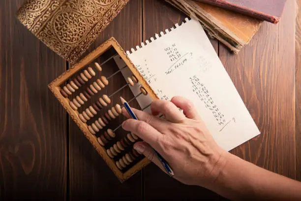 Vintage tone of women's hands doing accounting with old accounts . financial concept