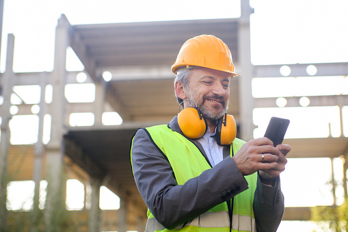 Adult male engineer on a construction site. About 50 years old, Caucasian male.