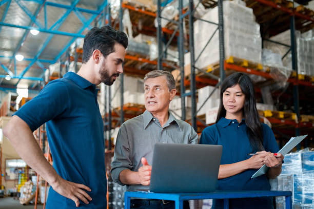 istock Male warehouse manager talking with employees 1423591735