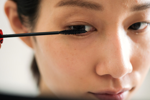 Closeup of woman applying mascara