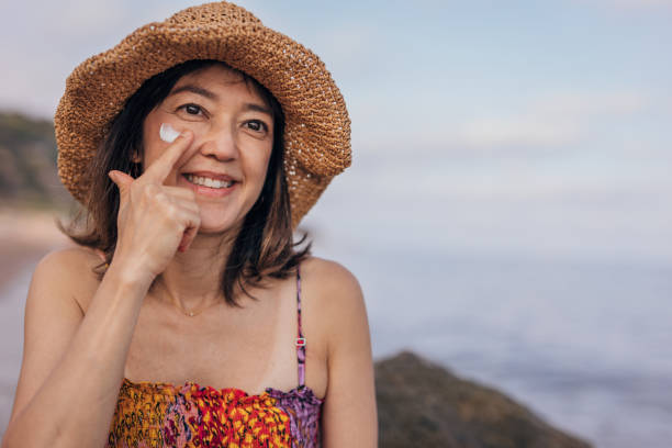 istock Japanese woman put lotion on face at a beach 1423593601