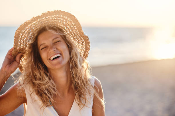 istock Cheerful woman with sun hat on the beach. 1423595965