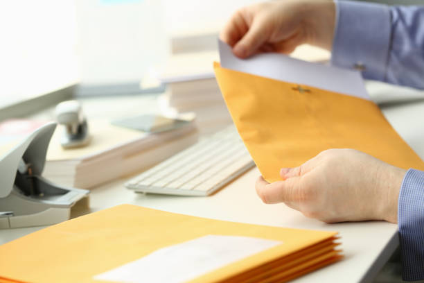 istock Businessman takes out documents from yellow envelope 1423600667