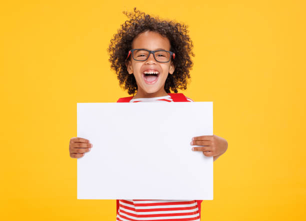 istock Happy ethnic schoolboy laughs and holds blank placard 1423600877