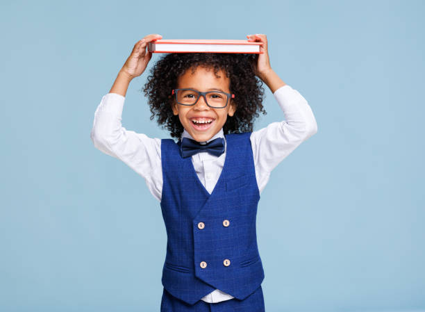 istock Happy ethnic schoolboy playing with book 1423600990