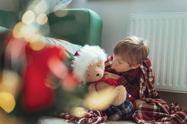 istock cute little boy dressing up teddy bear 1423602756
