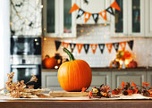 ハロウィーンの休日の秋の背景。キッチンの木製テーブルのカボチャ