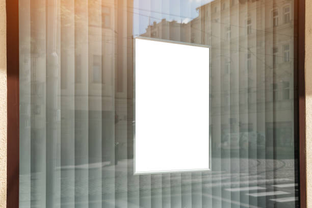 istock Vertical white poster hanging behind window case of store 1423604494