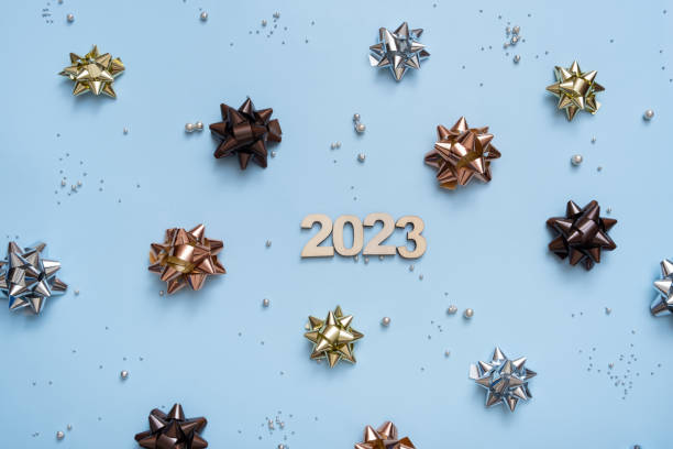 istock Numbers 2023 on bright festive background with bows and beads top view. Christmas background flat lay 1423604717
