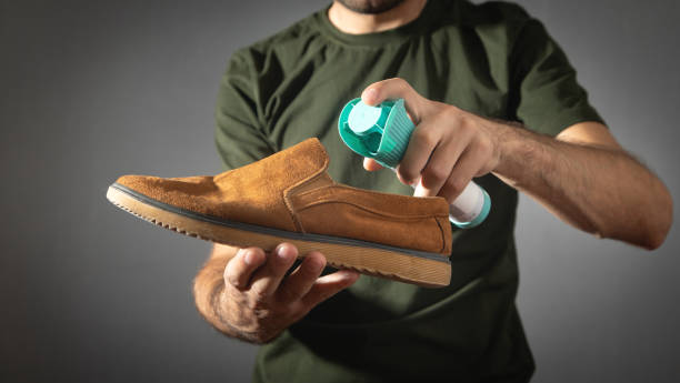 istock Man using antibacterial spray against unpleasant odors. 1423606062