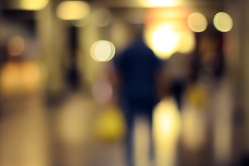 Blurry image of a subway with human silhouetes.