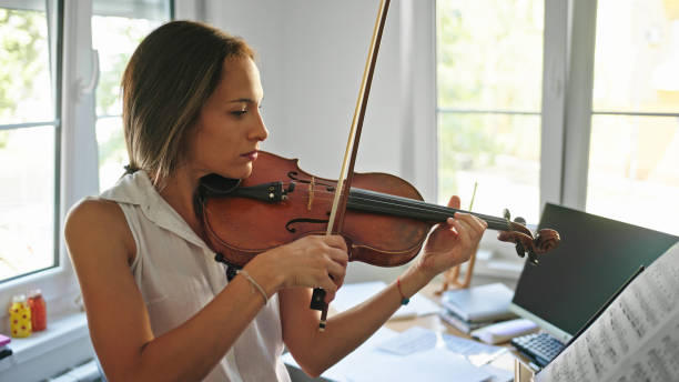 istock Young female violinist practicing at home 1423607585