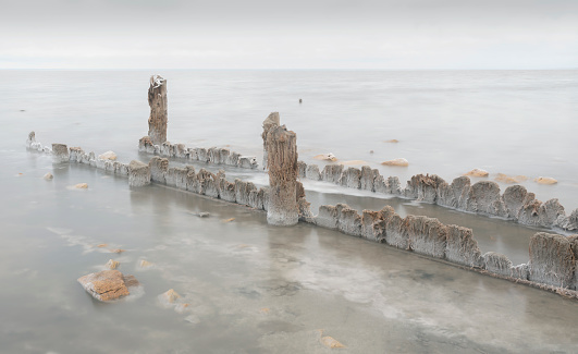 The remains of old wooden piles covered with salt crystals going into the salt lake Elton in the Volgograd region