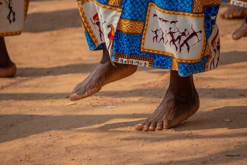 Women doing traditional dances barefoot in dirt soil
