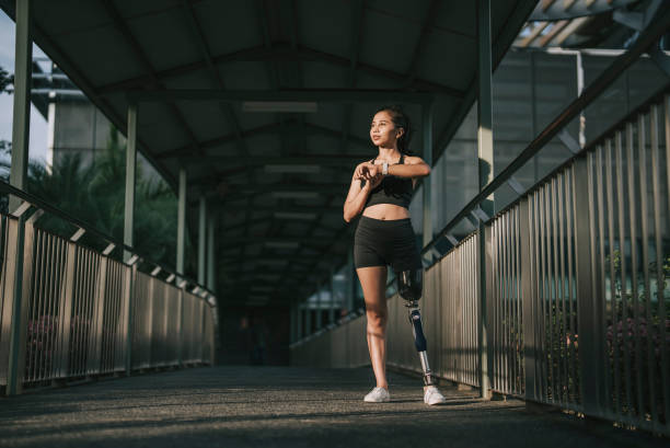 istock Asian female athlete with disability artificial leg checking her heart beat electrocardiography with fitness tracker at pedestrian walkway bridge after jogging in the morning 1423617316